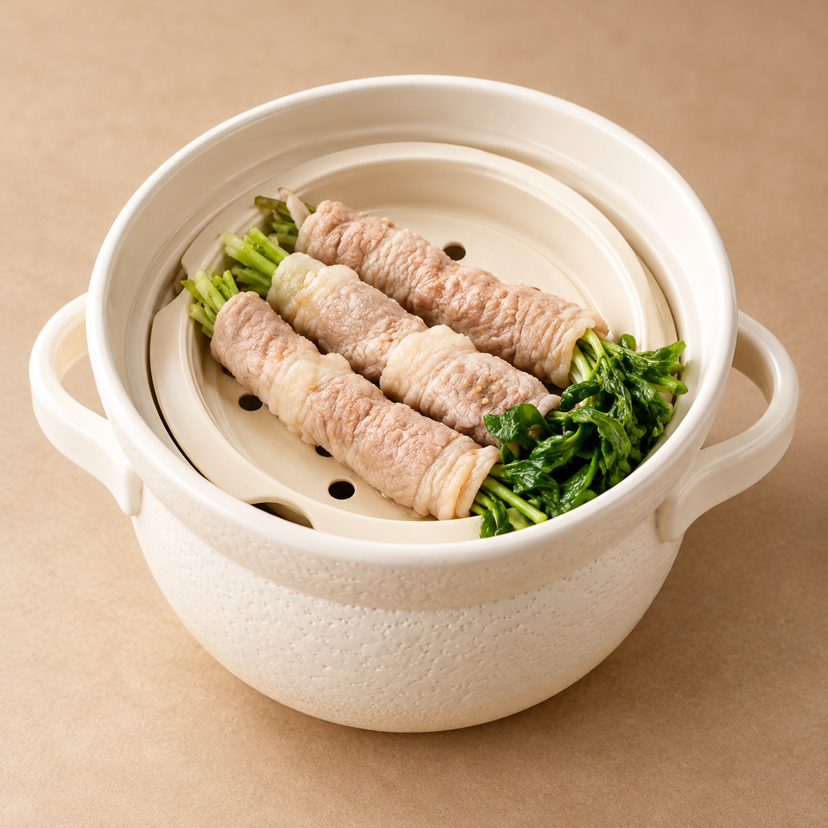 White INAHO donabe steamer holding three pork and green vegetable rolls.